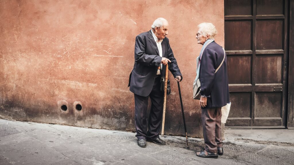 Two old men talking together on a street