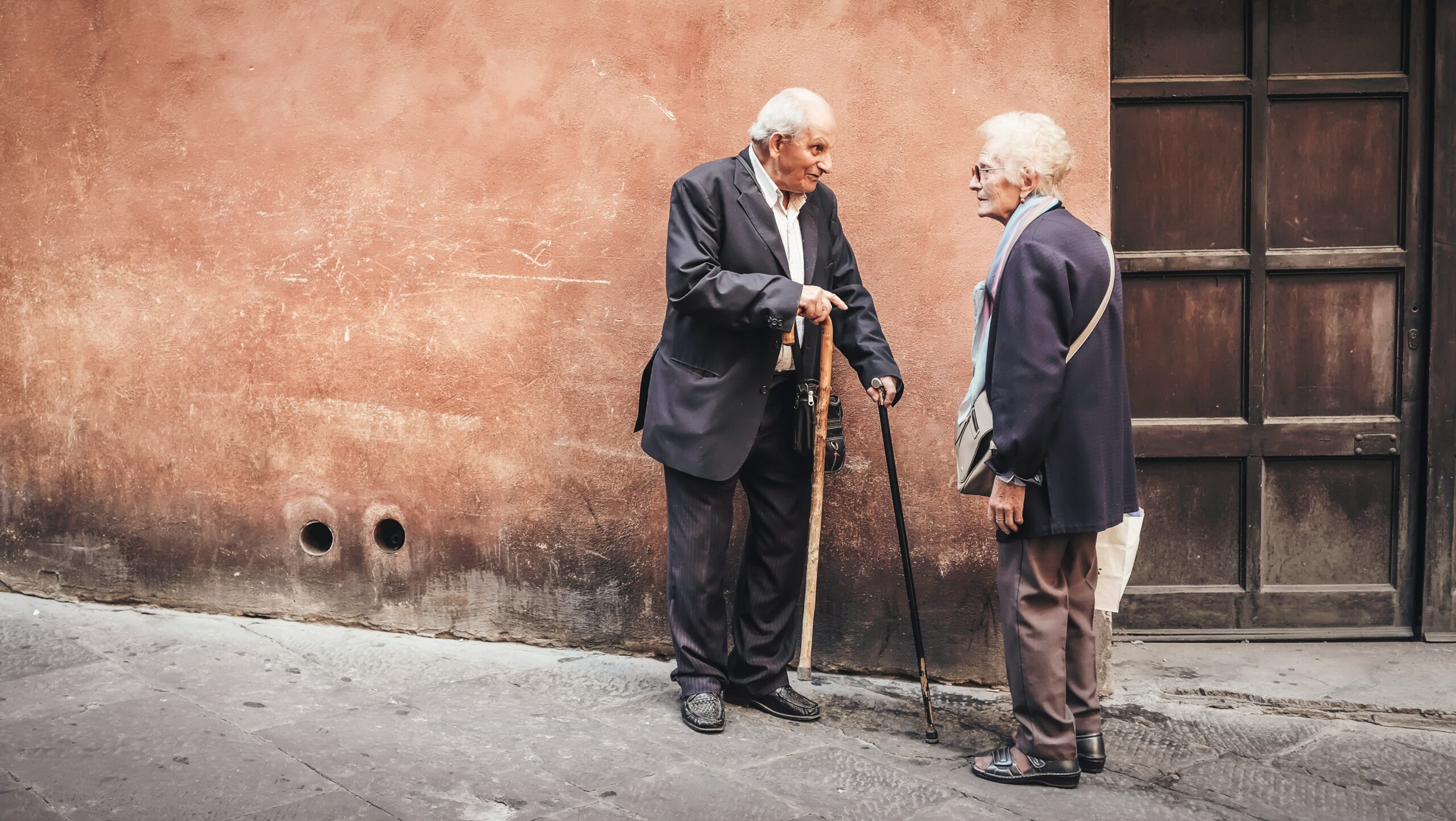 Two old men talking together on a street